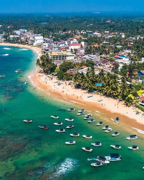 Aerial view of Hikkaduwa turquoise ocean bay and boats
